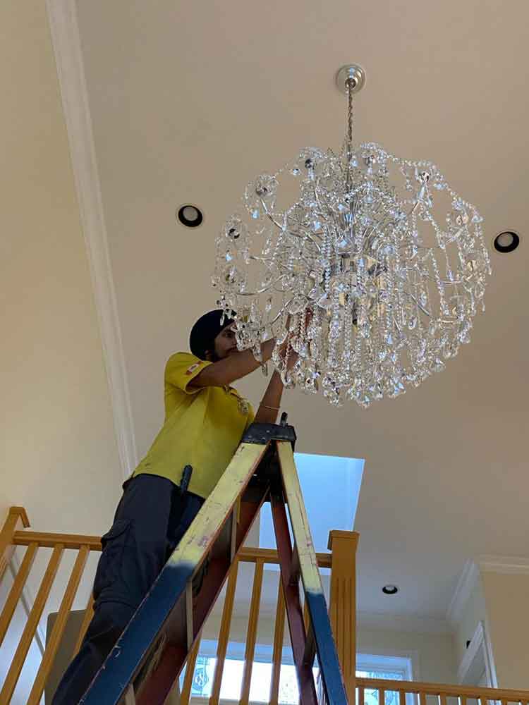 Bumblebee Clean worker cleaning chandelier